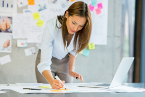 A woman reviews plans in an office.